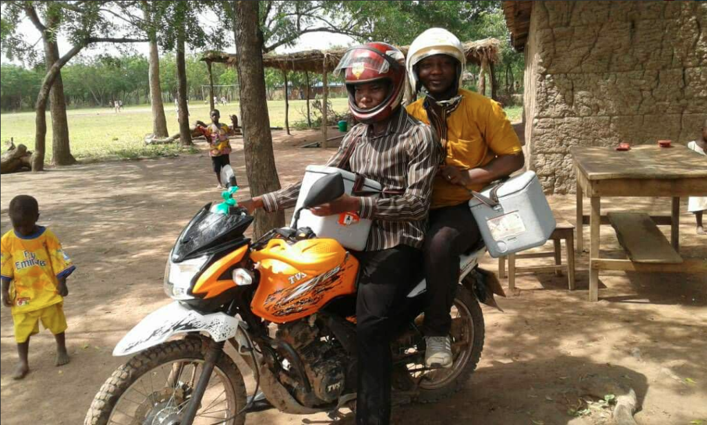 Edmund hopping on a bike to provide immunisation services in hard to reach island communities in Afram Plains, Ghana.
